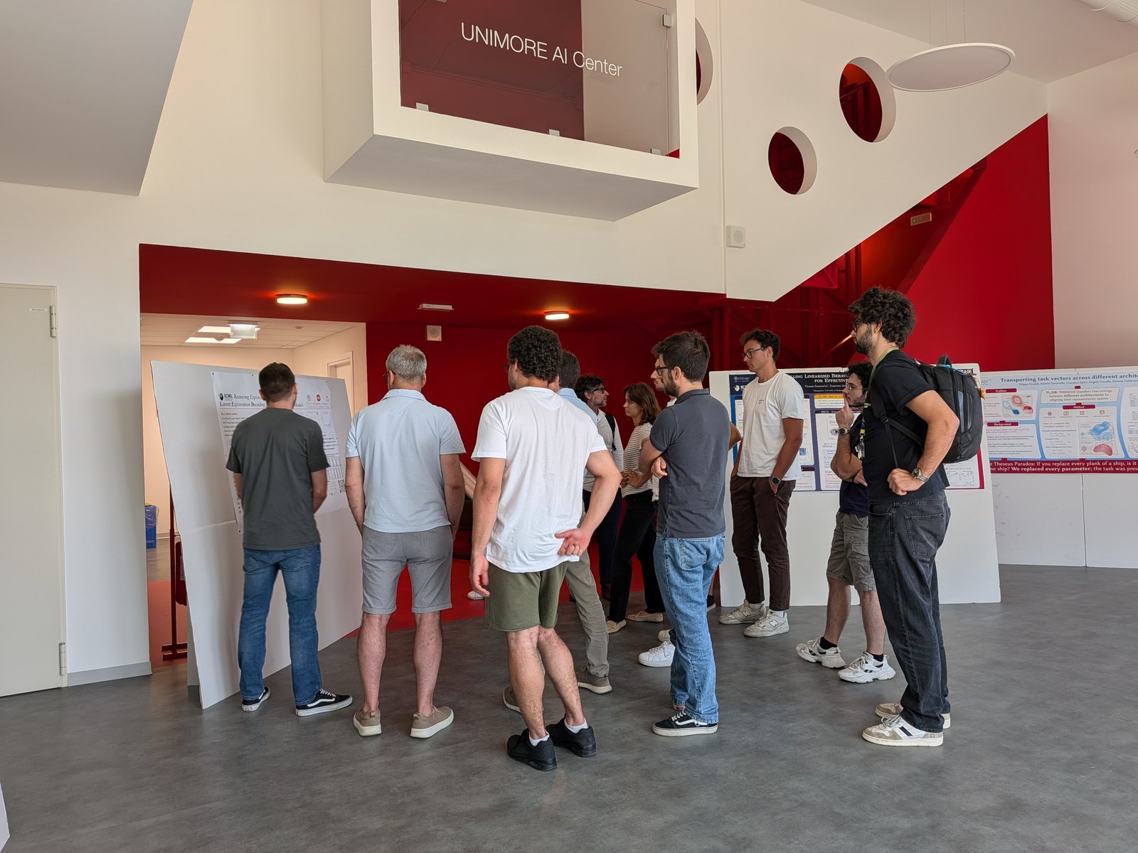 Researchers at the posters in the hall of the UNIMORE AI Center